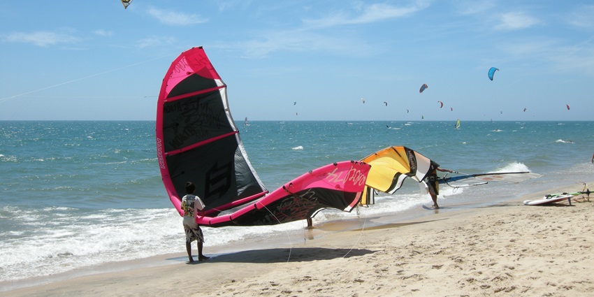 Kitesurfing in Mui Ne Beach, showcasing Vietnam's wide sandy shore and vibrant blue waters.