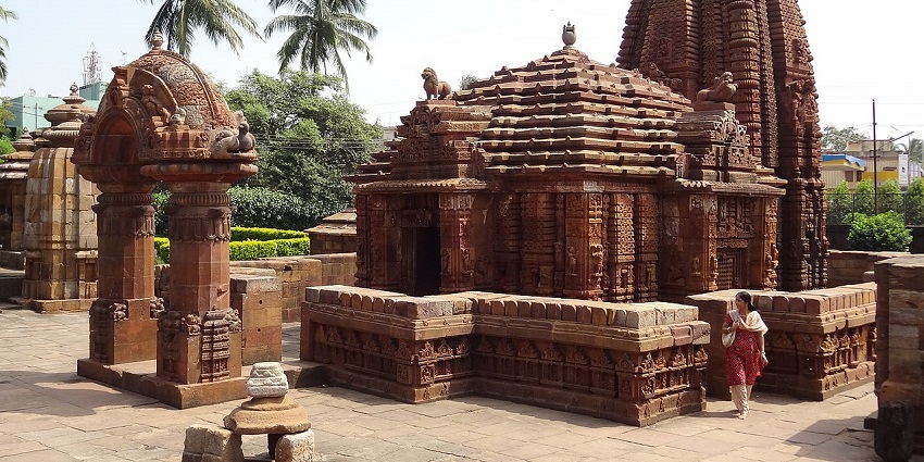 View of a historic holy shrine with clear sky and lush green trees in the background.