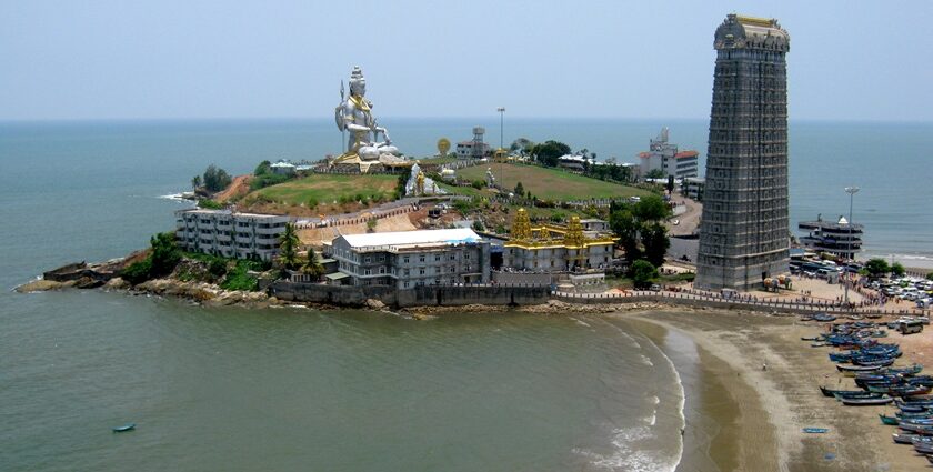 An aerial view of a majestic statue of Shiva surrounded by azure waters and golden sands.