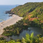 A breathtaking view of an azure water body with a lush green island on the side.