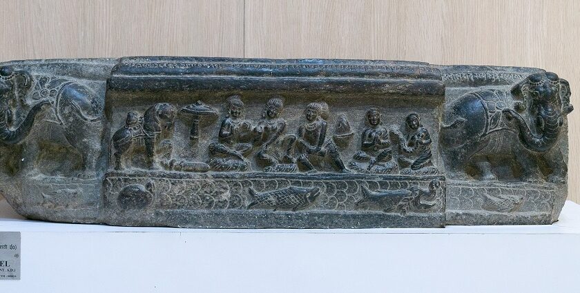 A stone panel with carvings for people and animals displayed in Nalanda Museum.