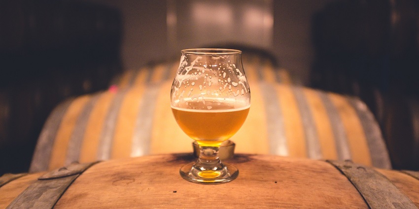 An image of a glass of chilled beer on a wooden table a place to enjoy Bhutan nightlife.