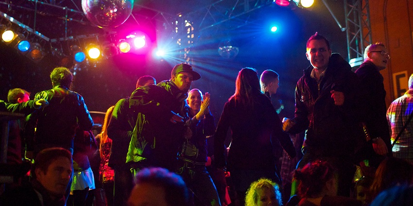 Crowd dancing at a disco party and depicting the best Nana Plaza Bangkok nightlife.