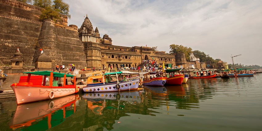 An image showcasing Narmada Ghat, clamouring with travellers and a peaceful waterway.