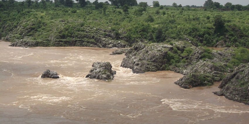 A scenic view of the Narmada river flowing at its pace, one of the most peaceful places to visit near Madhya Pradesh
