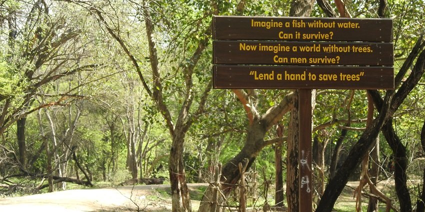 A warning sign near the lake in the sanctuary amidst the forests, perfect for hiking.