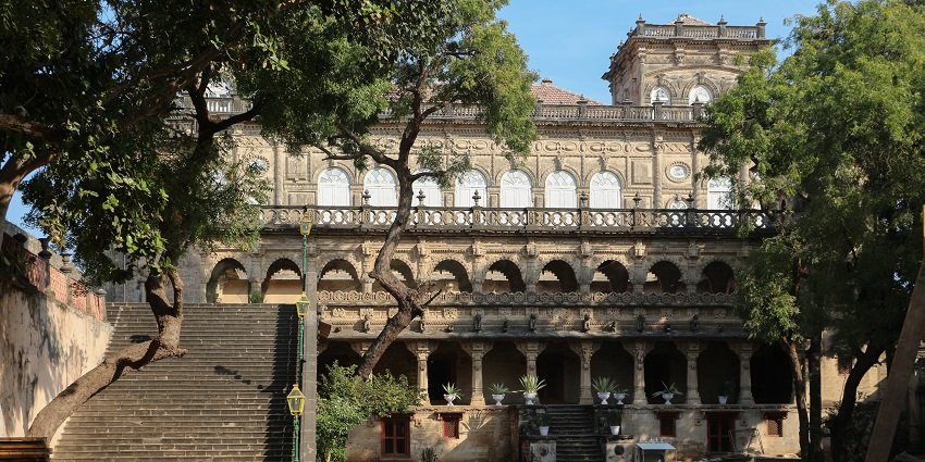 Majestic Naulakha Palace with intricate architecture, set against a historical backdrop.