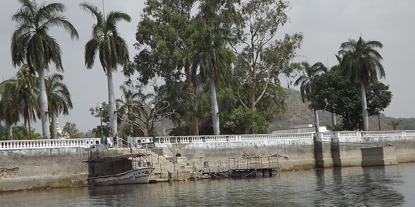 A scenic park in Sikar, with a pond in front, surrounded by lush greenery all around 