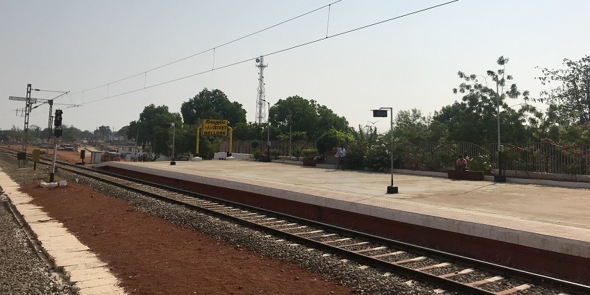 Close-up of Nellore railway station board displaying station name in English and Telugu.