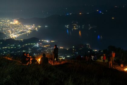 Vibrant night street view of Kathmandu with cars, bustling Nepal nightlife for singles.