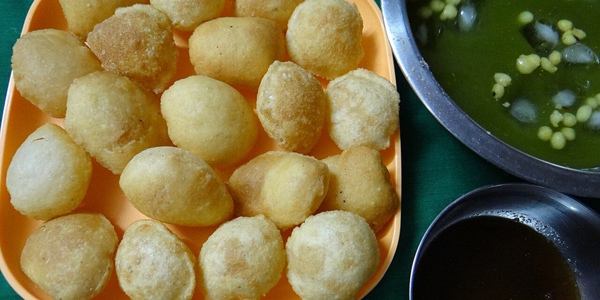 Crispy hollow pani puris filled with spicy water, chickpeas, potatoes, chutneys—street food in khan market
