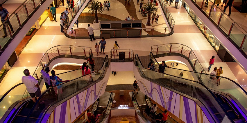 A lively group of people inside a mall, browsing shops and enjoying their shopping experience