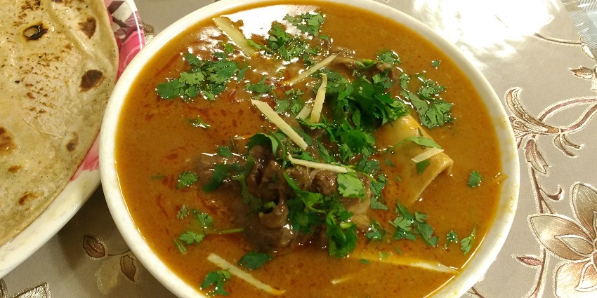 A delicious serving of Nihari, showcasing tender meat in a spicy broth, topped with cilantro