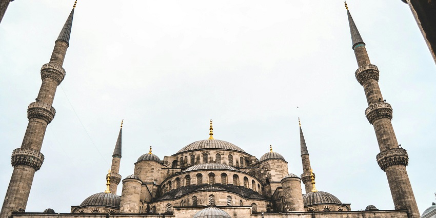A low-angle view of a tall building with intricate architectural details and geometric designs.