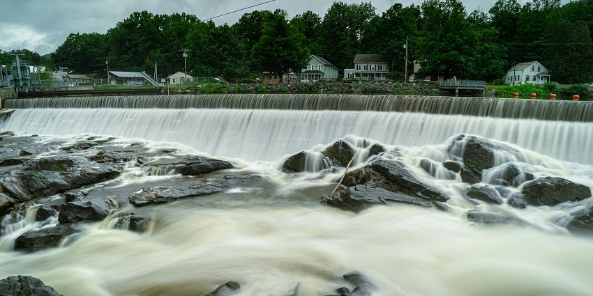 Scenic image of across the Dam and the small village situated near it, amidst the lush forest