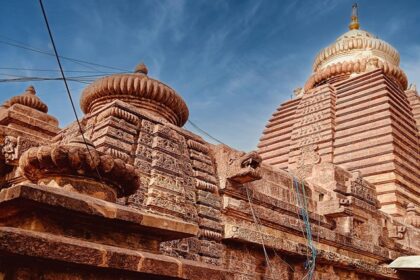 An image of a majestic ancient stone temple in Odisha under a clear blue sky.