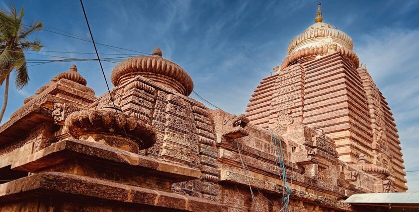 An image of a majestic ancient stone temple in Odisha under a clear blue sky.