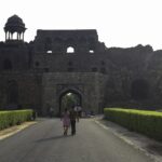 A frontal view of the Old Delhi Fort with a walkway leading to the fort and gardens on both sides