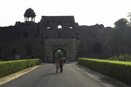 A frontal view of the Old Delhi Fort with a walkway leading to the fort and gardens on both sides