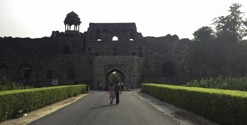 A frontal view of the Old Delhi Fort with a walkway leading to the fort and gardens on both sides