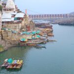 View of the Narmada River near Omkareshwar Temple, showcasing the river's flow and temple backdrop.