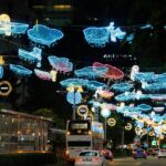 A car driving down a street covered in Christmas lights at Orchard Road in Singapore.