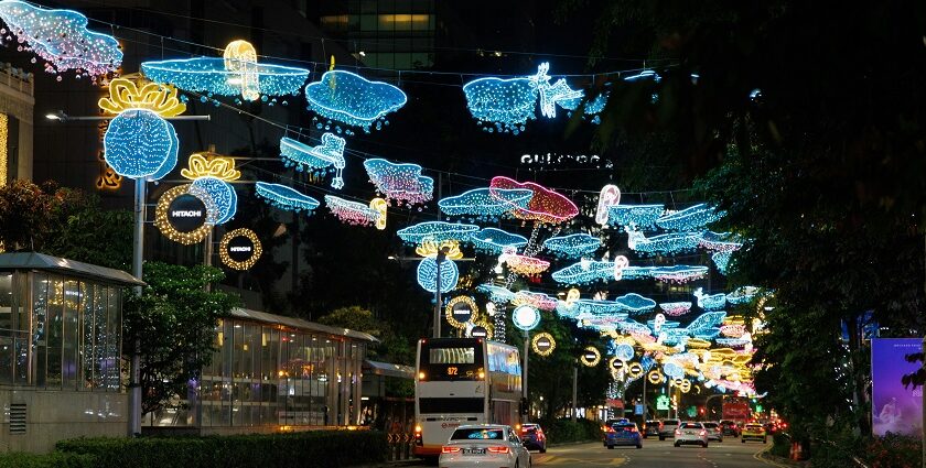 A car driving down a street covered in Christmas lights at Orchard Road in Singapore.