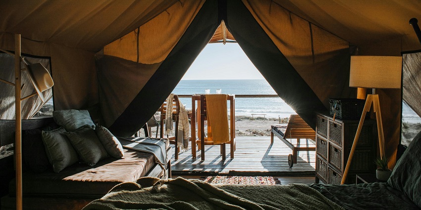 Image of a cosy tent with bed and terrace on beach - picnic places near Ahmedabad