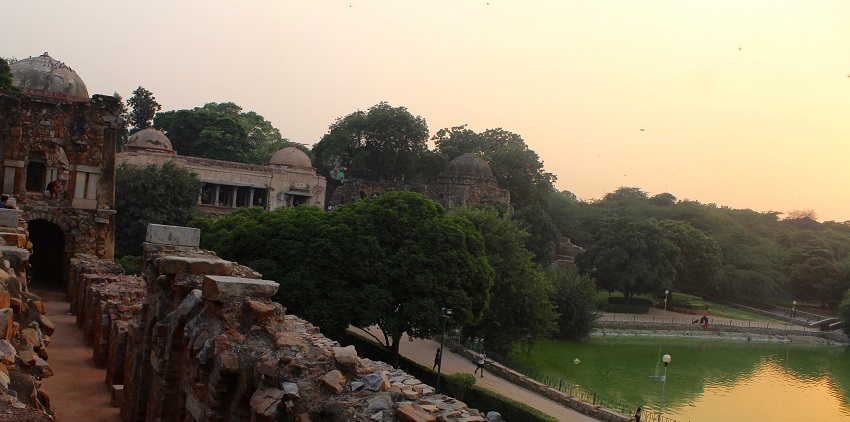 A picture of a fort and its nearby area taken from its balcony with a pond of water also visible