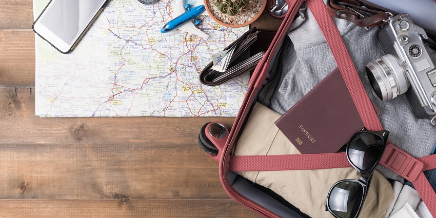 Preparation accessories for the trip and travel items with a map on a wooden board.