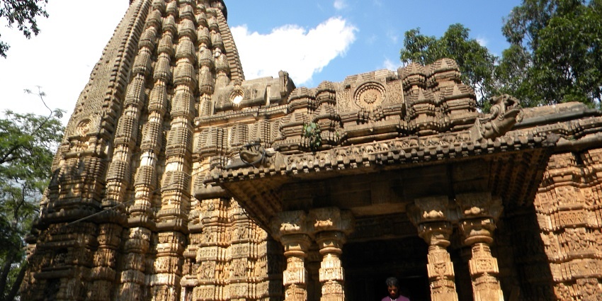 Two people are climbing down the stairs and exiting the Bhoramdeo Temple, Chattisgarh.
