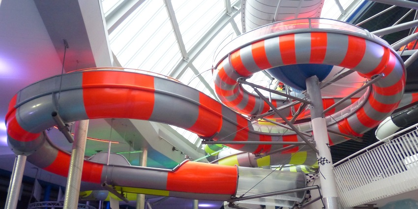 Wide angle view of a large water slide, descending down into the pool