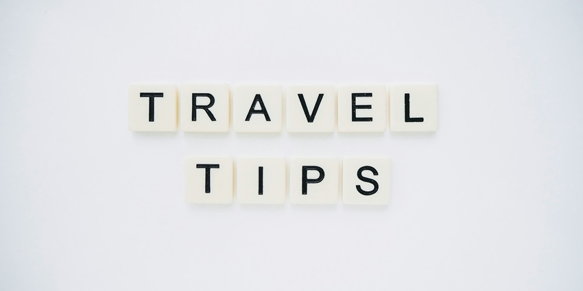 A frontal view of a plain white surface with white and black blocks saying travel tips.