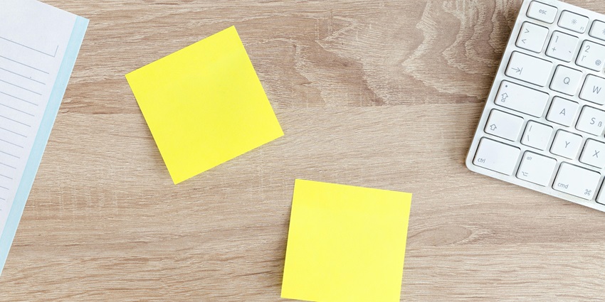 A stunning aerial shot of sticky notes on a table with a keyboard and copy on the side.