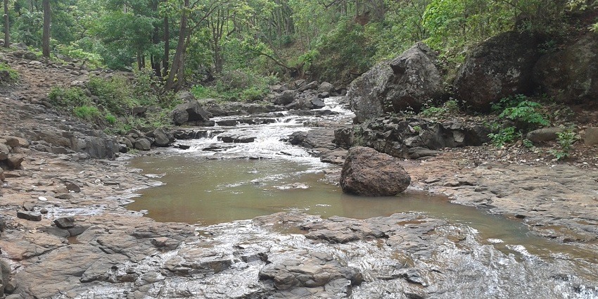 Narmada River flowing through Amarkantak, surrounded by lush green hills.