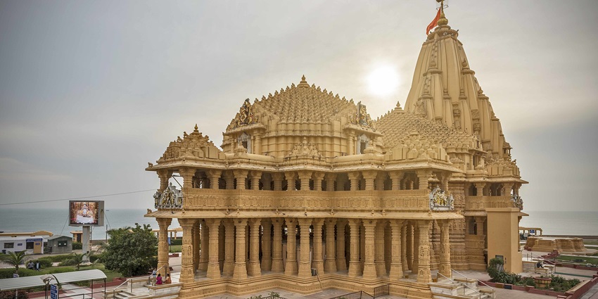 A picture of the Somnath temple with the sun shining bright in the background