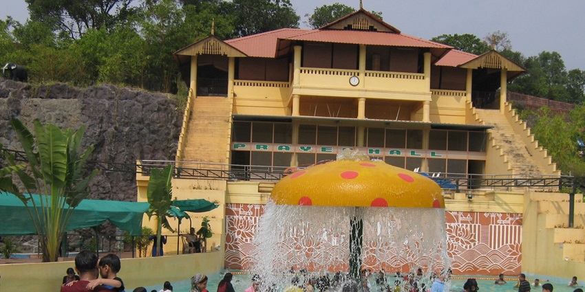 Image of a water park with colourful and adventurous rides, children playing around