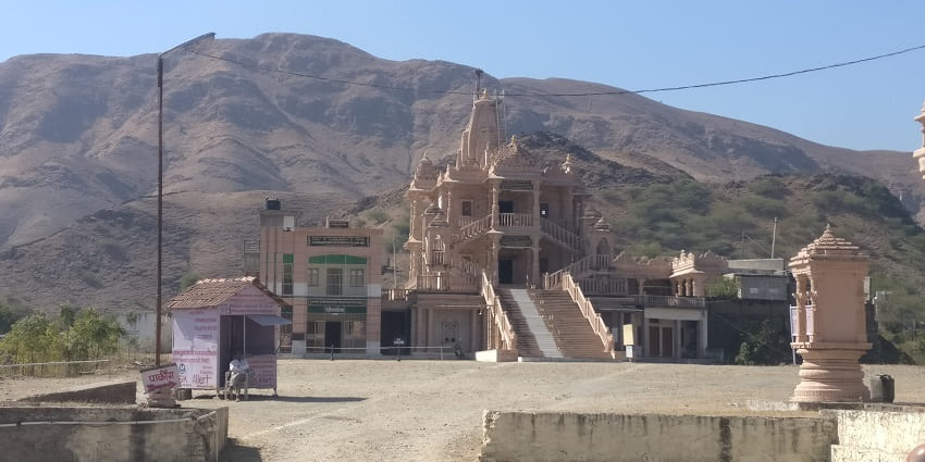 Distant shot of the Shamlaji temple with mountain ranges in the background