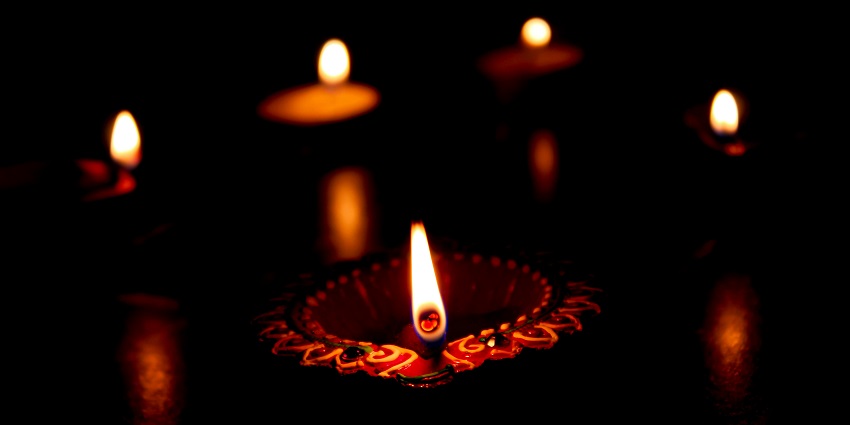 Lit candles glowing softly against a dark background, creating a serene ambiance.