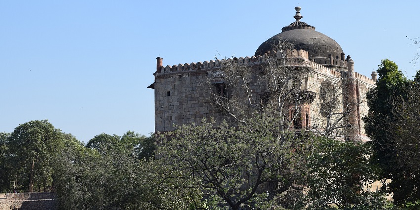 Distant view of the fort against the clear blue sky, surrounded by lush greenery