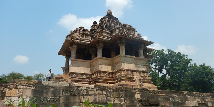 View of the Nandhi Temple in Khajuraho, India, with a central sculpture of Nandi and detailed carvings on the walls.