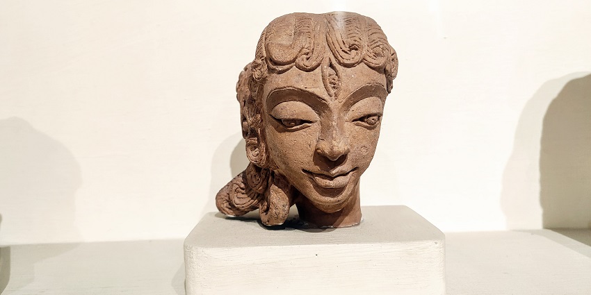 Intricate historical stone sculpture of a woman, showcasing timeless artistic beauty.