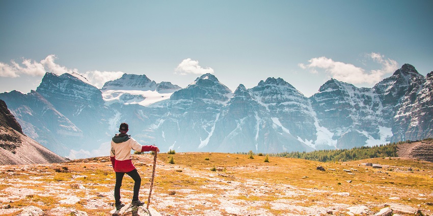 Image of a man on trek standing and admiring the view of the mountains
