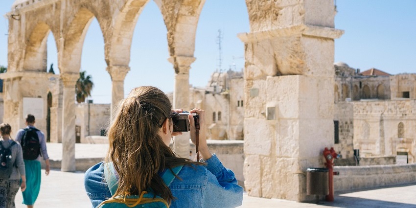 A tourist woman clicking pictures of the fort so as to keep memories.