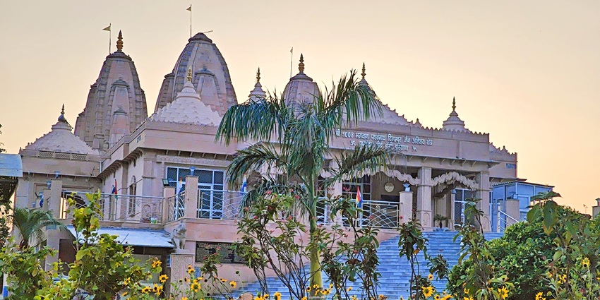 View of the templet against the vibrant sun hues in the sky, surrounded by sunflowers
