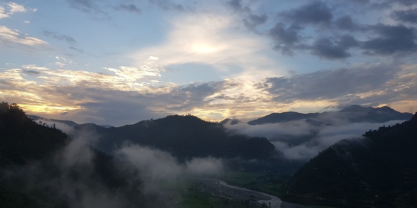 A scenic view of foggy hills and mountains in Nepal during the evening time.