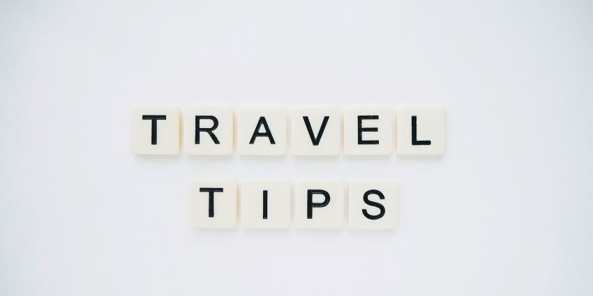 A frontal view of white blocks placed on a plain white surface saying travel tips.