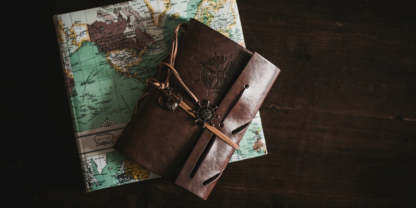 An image of a diary and map with various items, for a visit to the Dolls Museum Rajkot.
