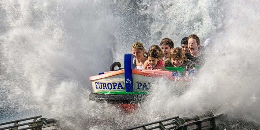 Children giggling as they glide down colourful water slides, showing their excitement.