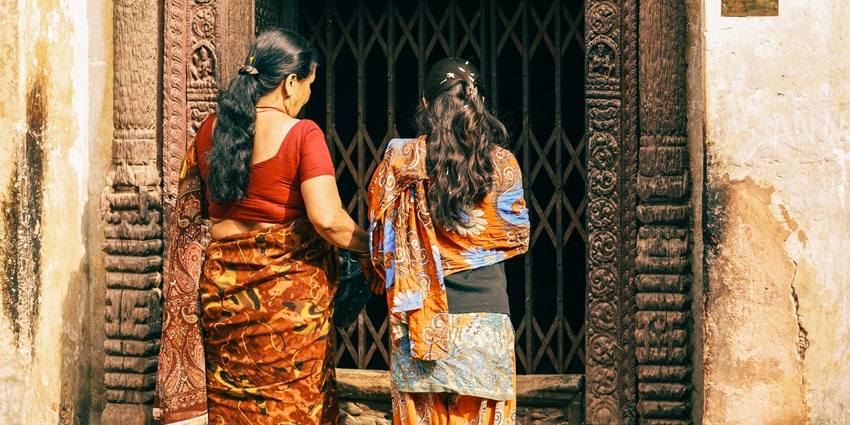 Indian woman in traditional saree, entering the temple’s compound.
